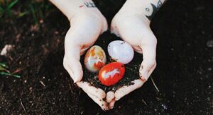 Yoni eggs held in hands with earth